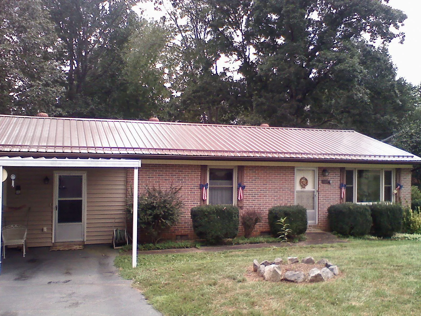 Bronze metal roof and carport on a brick ranch home — Roof Repair work by our crew in Cottonwood